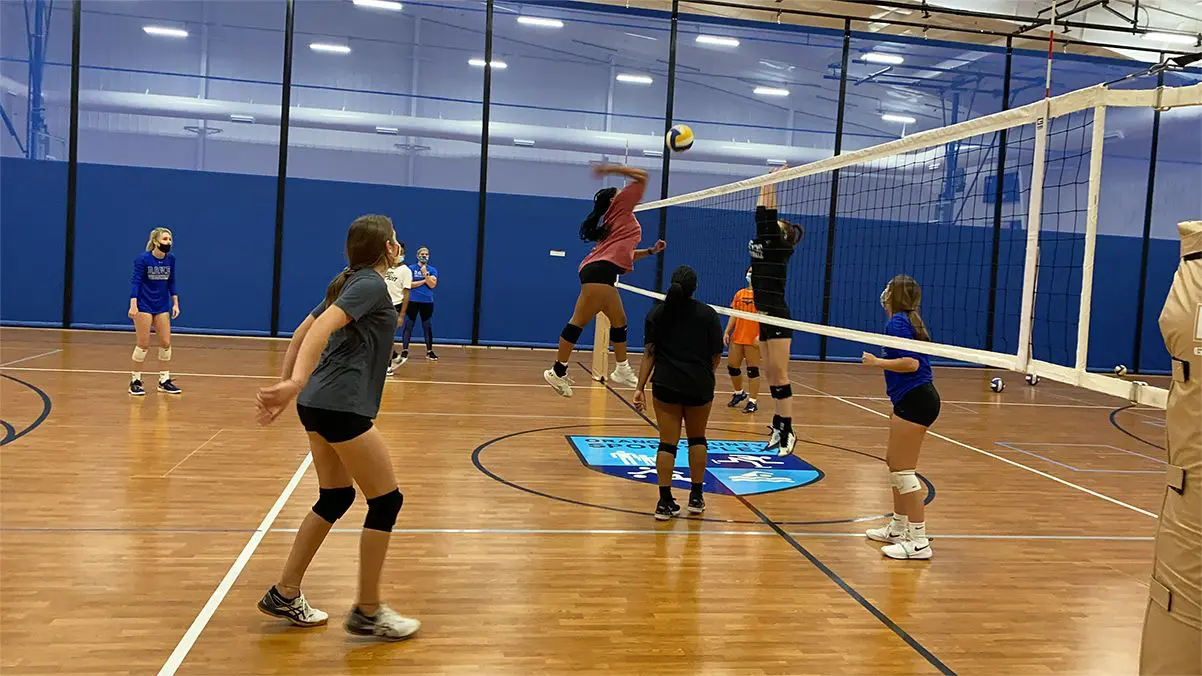 Focused female volleyball player blocking served